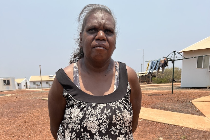 a woman standing in front of a house.