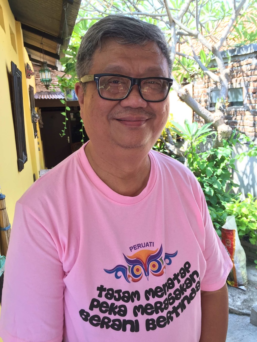 Indonesian gay rights campaigner Dede Oetomo, smiling at the camera. He is wearing thick-rimmed glasses and a pink t-shirt.