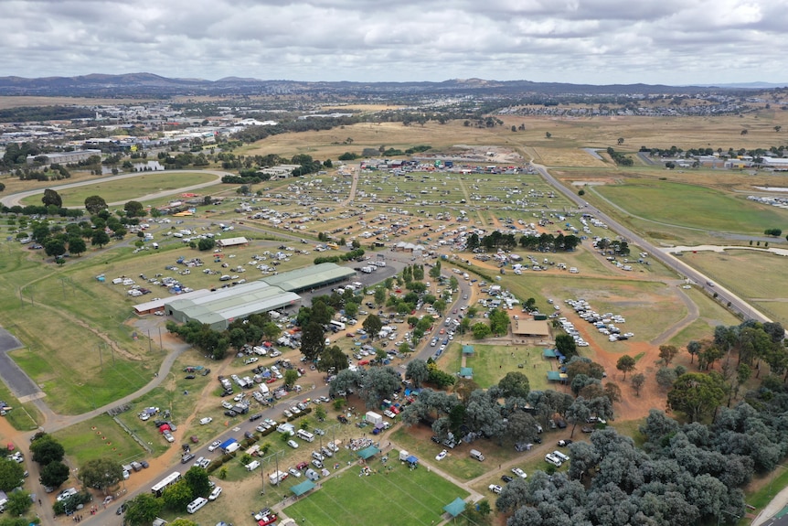 Aerial view of people and tents at a show ground. 