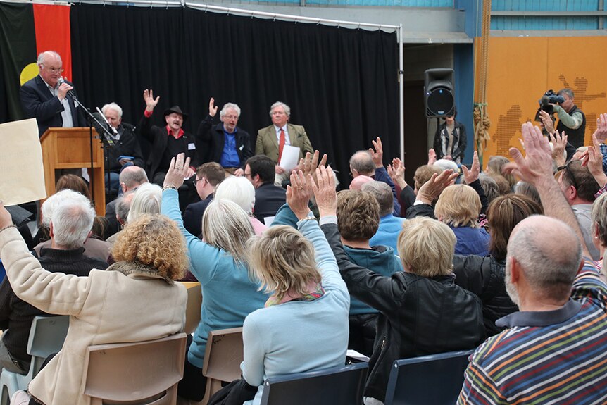 People vote at a public meeting against Anglican Church sales