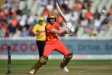 Ellyse Perry plays a cut shot while representing the Birmingham Phoenix. She is in an orange and gold uniform
