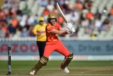 Ellyse Perry plays a cut shot while representing the Birmingham Phoenix. She is in an orange and gold uniform