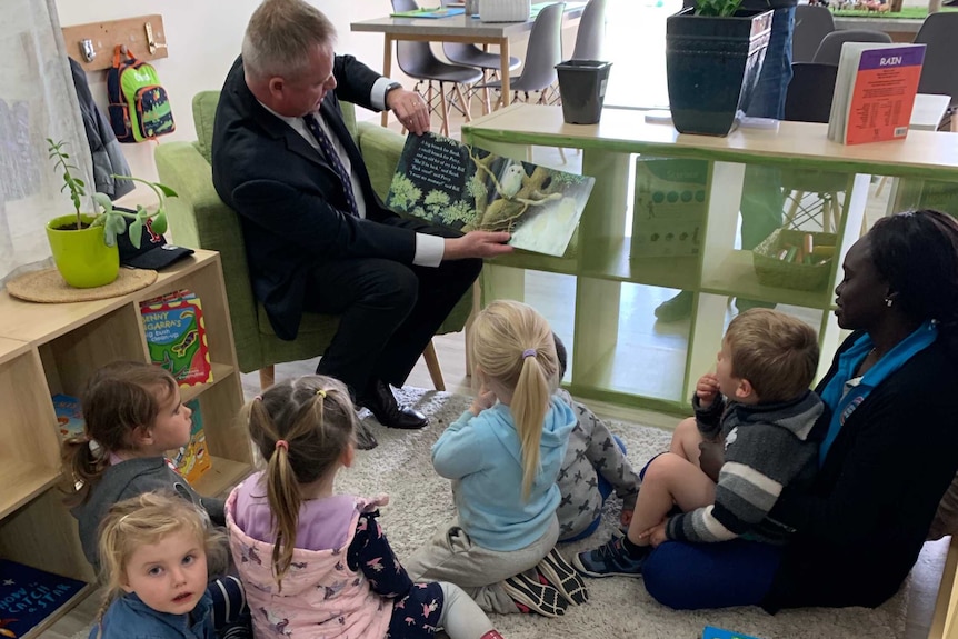 The education minister reads to children.