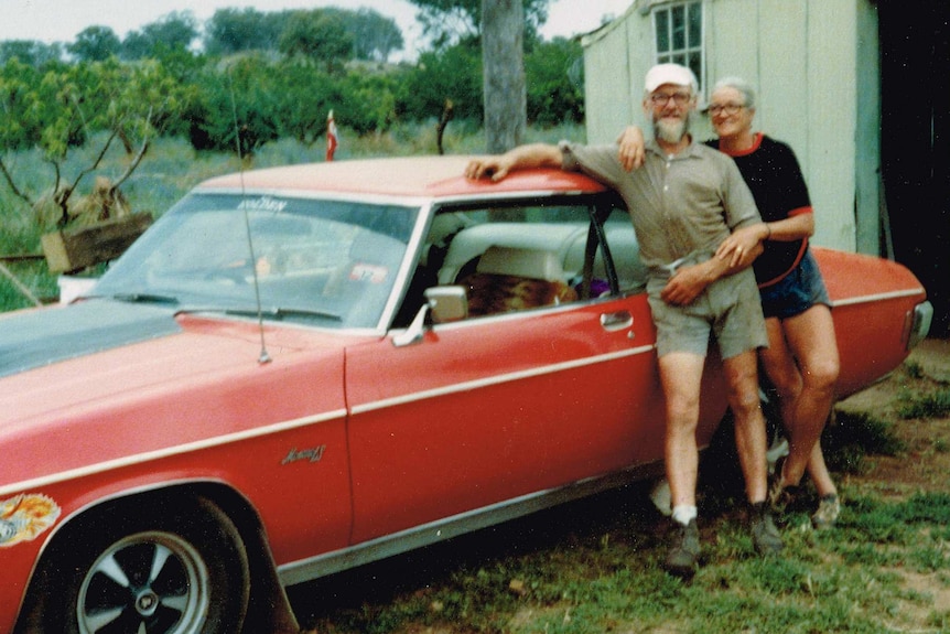 Kathleen and Peter Golder with their red Chevrolet car.