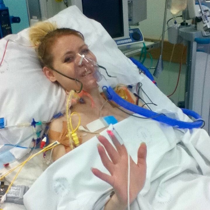 A woman in a hospital bed with an oxygen mask on.