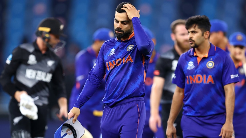 Virat Kohli puts his hand on his head in frustration as he walks from the field