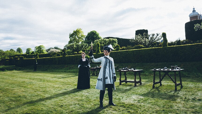 Emma Stone and Rachel Weisz standing on lawn in 2018 film The Favourite.