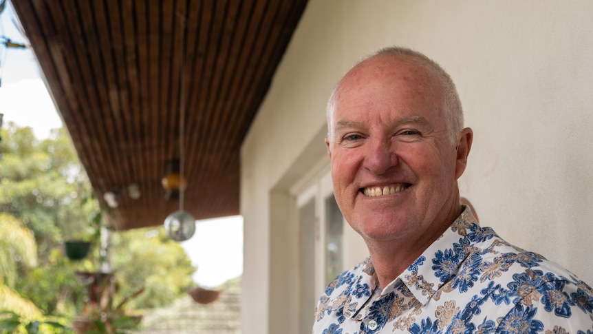 A smiling man on the veranda of a house