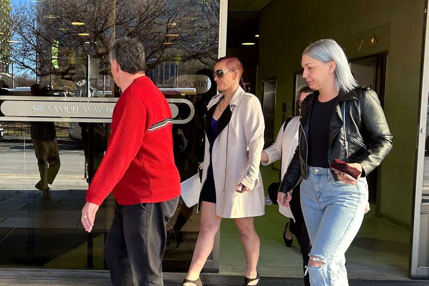 two women and a man walks out of the Adelaide Magistrates court