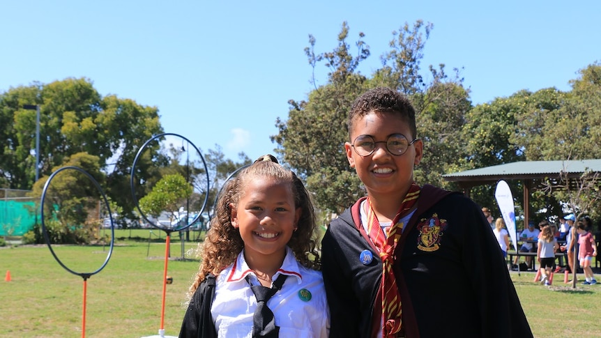 boy and girl dressed up in Harry Potter-inspired clothing at kidditch pitch