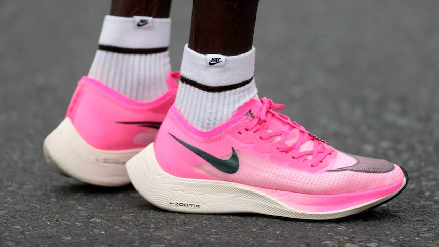 A close up of the pink running shoes worn by a runner.