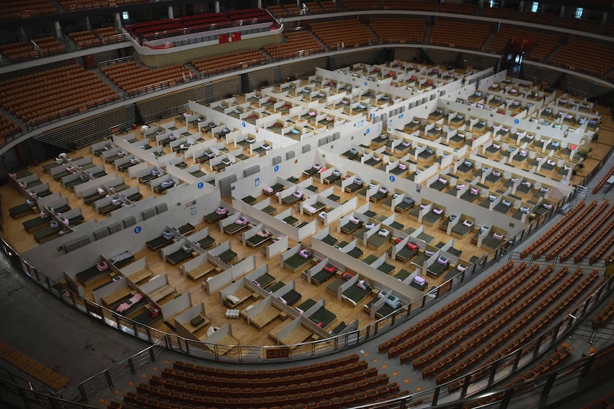 A sports stadium filled with beds.