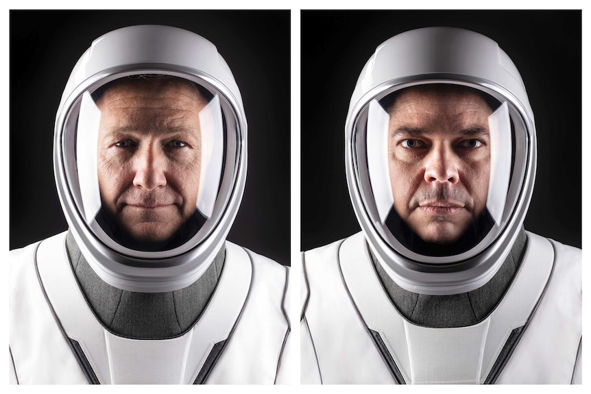 Doug Hurley and Bob Behnken stare ahead through the helmets of their spacesuits at SpaceX headquarters.