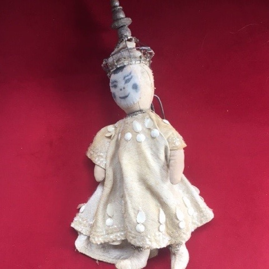 A thai baby doll in a dress and crown from a theatre production of the King and I