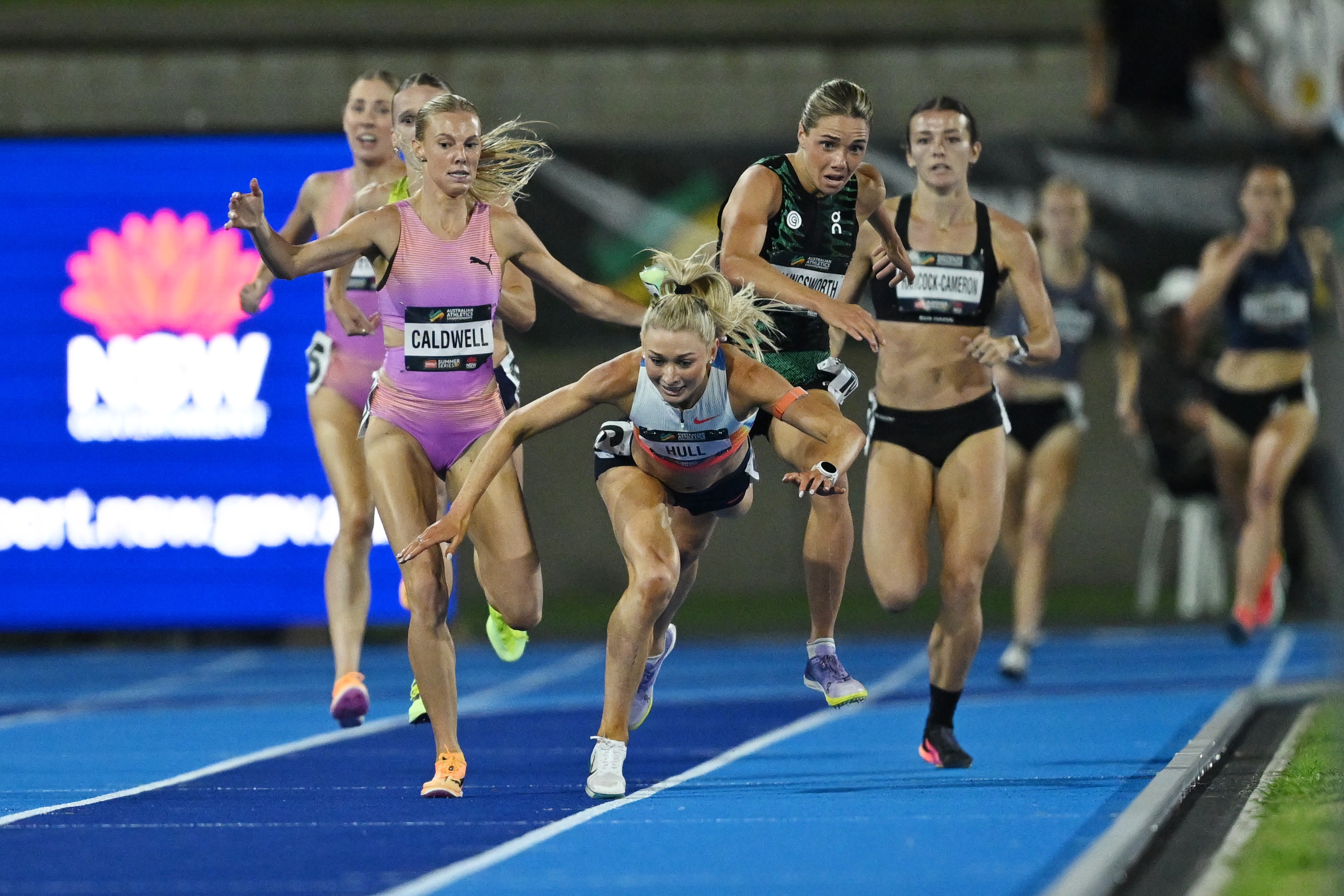 Jess Hull começa a cair no chão enquanto Abbey Caldwell e Claudia Hollingsworth continuam atrás dela