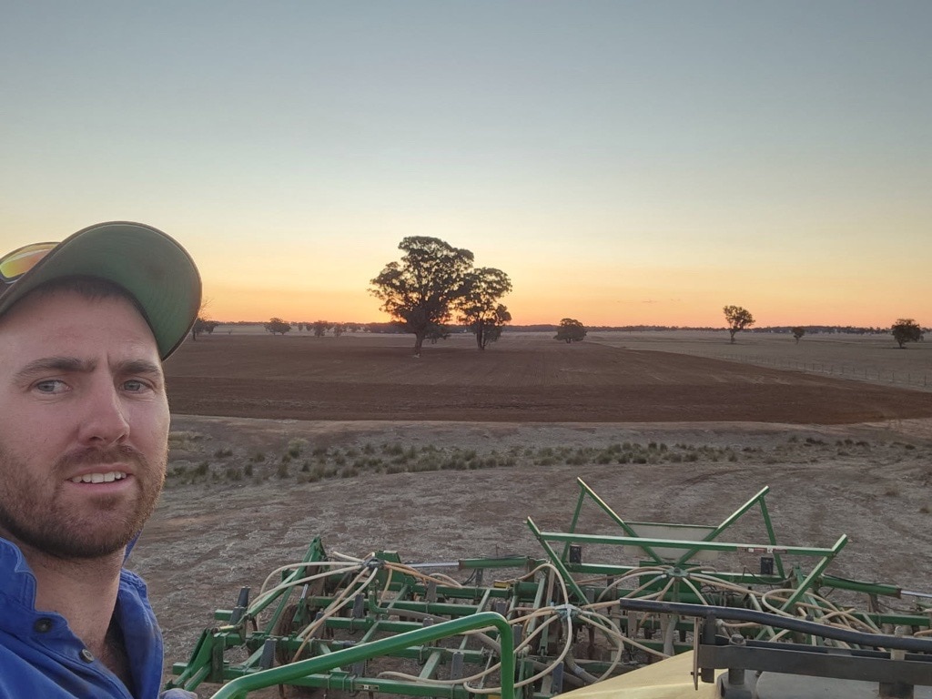 Selfie of Aaron with the backdrop of his paddock in the sunset 