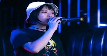 Chinese International student Sophie holds a microphone at a karaoke bar.