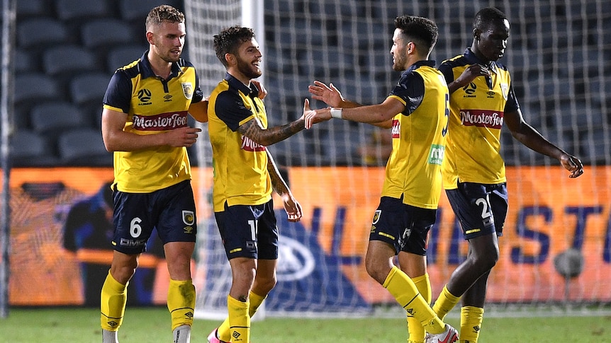 Four Central Coast Mariners players celebrate an A-League goal