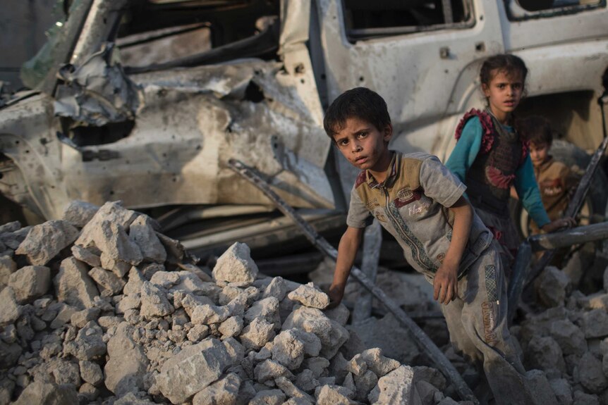 Iraqi children flee through rubble from IS fighters
