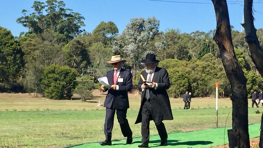 Two men walk through Rookwood cemetery in Sydney.