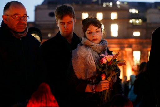 People bring flowers to a vigil in Trafalgar Square for the victims of the London terrorist attack on March 22 2017.