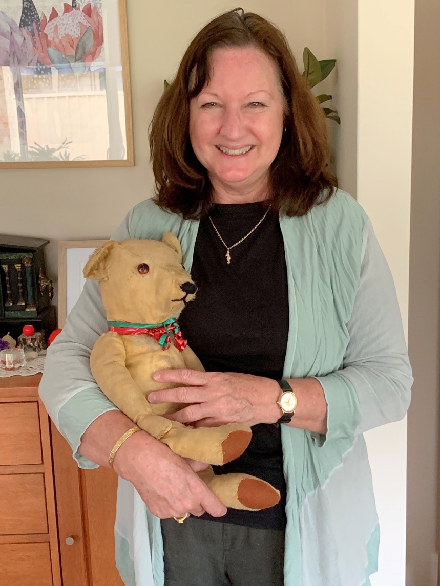 woman holding teddy, smiling