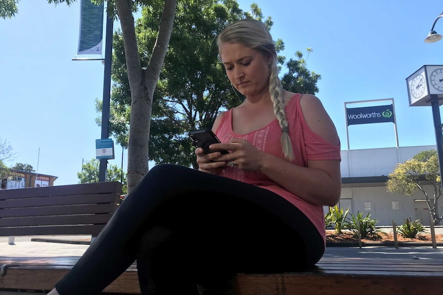 A woman sitting on a bench looking at her smart phone