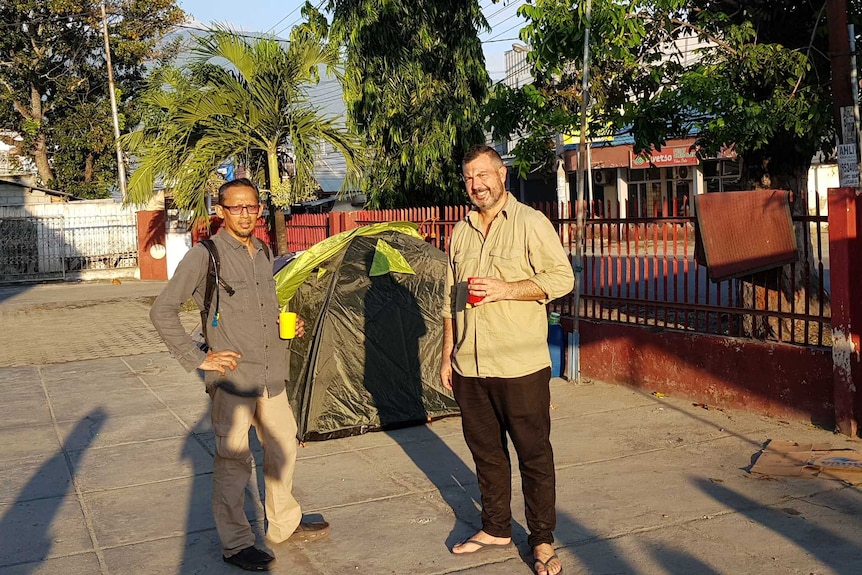 Wu and Hemingway standing next to tent.