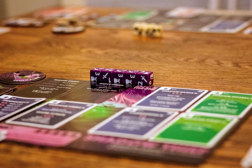 A generic image of an unnamed board game, with many dice and card in focus.