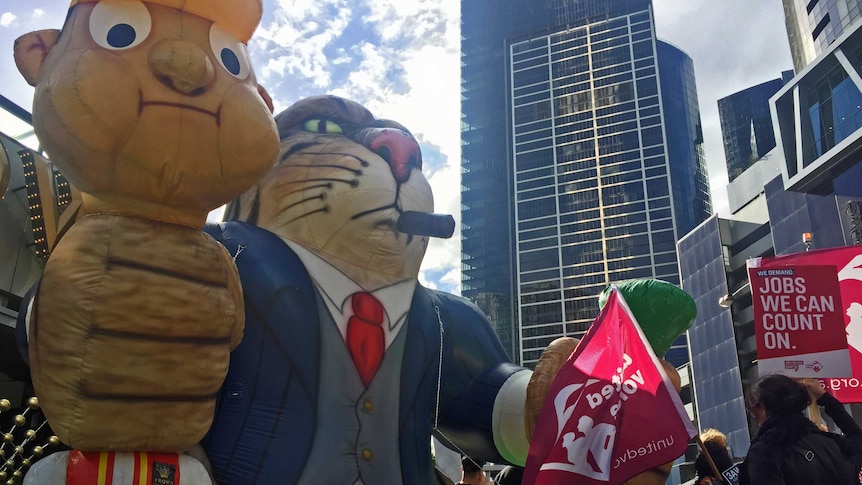 A blow-up fat cat strangles a worker outside the Crown Casino.