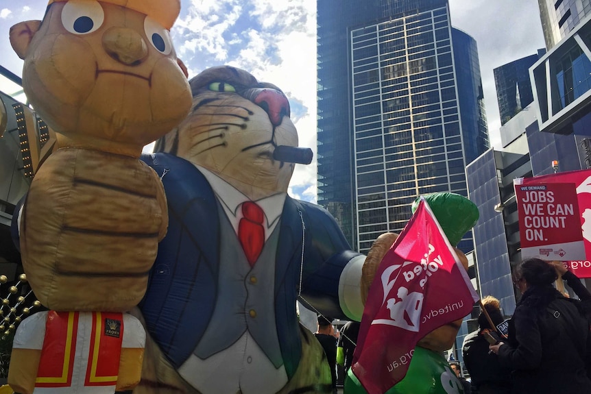 A blow-up fat cat strangles a worker outside the Crown Casino.