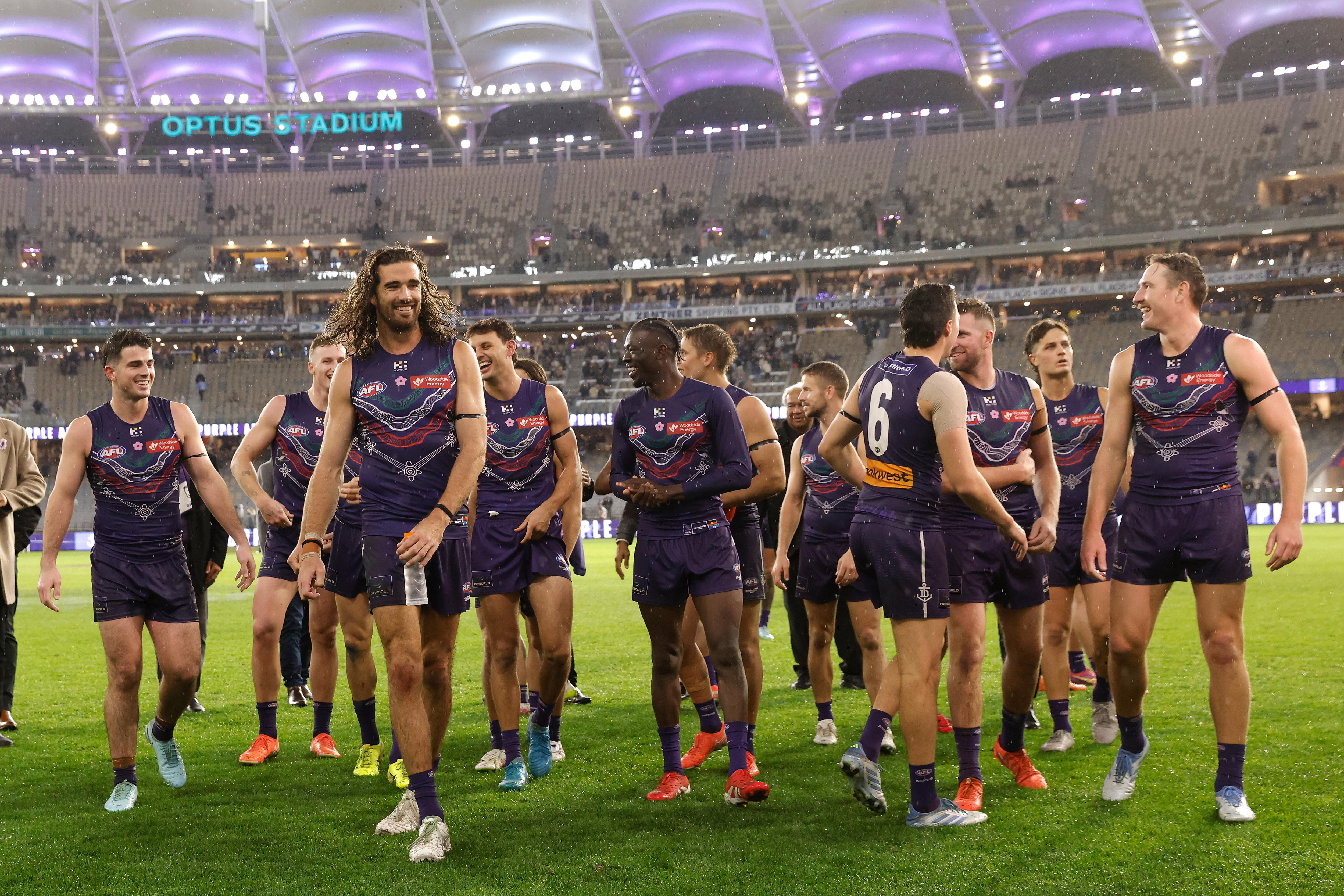 Fremantle players leave the field on a rainy night.
