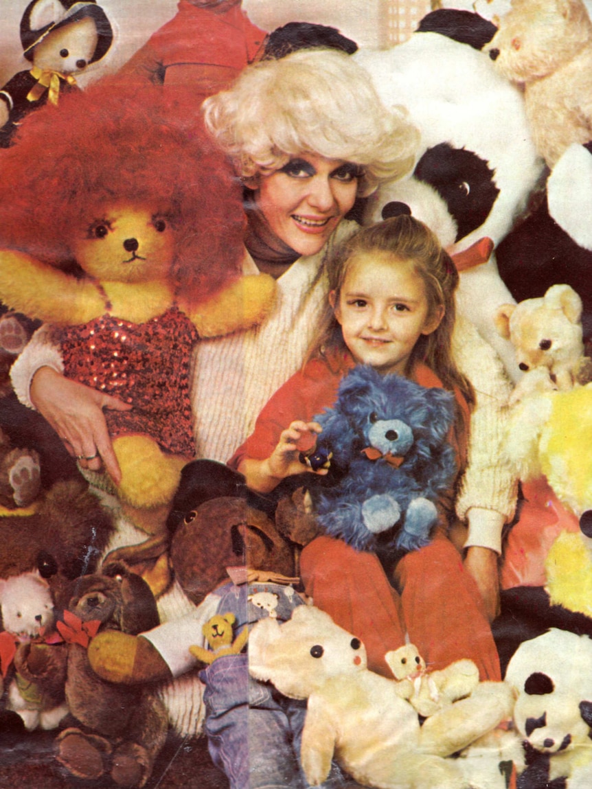 A little girl and her mum sit surrounded by teddy bears