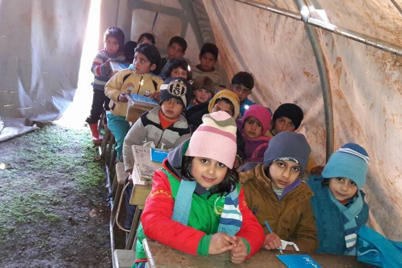 Syrian children in refugee camp classroom tent