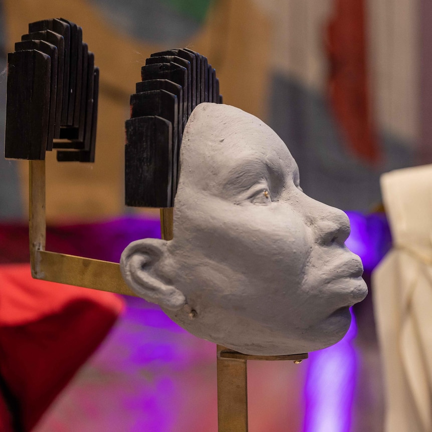 A bust of Nina Simone showing two layers of hair crafted out of black piano keys, Hildegard's bust is out of focus