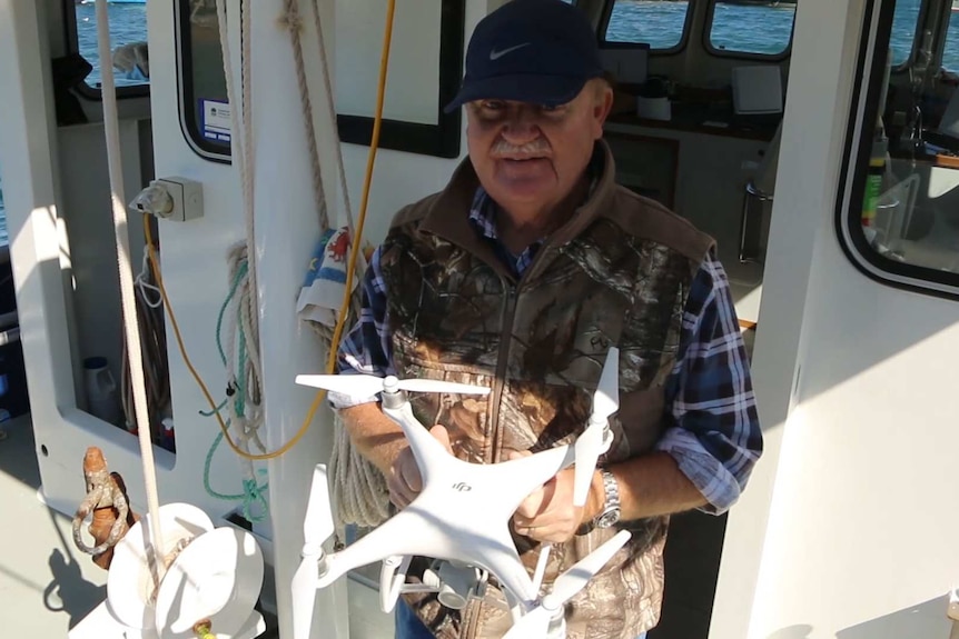man holding drone on boat