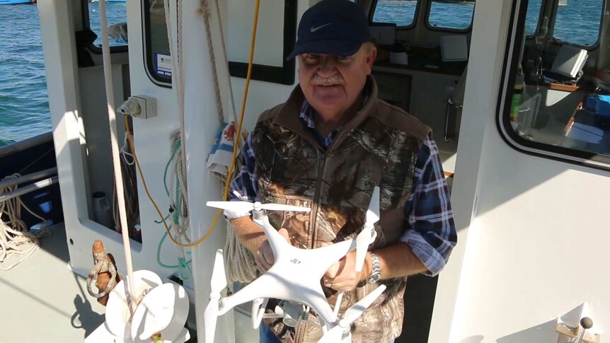 man holding drone on boat