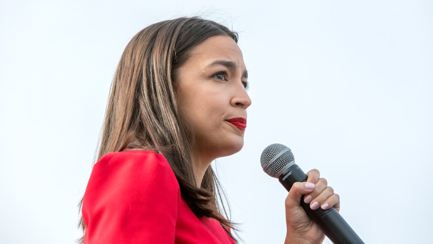 Representative Alexandria Ocasio-Cortez with a microphone in her hand