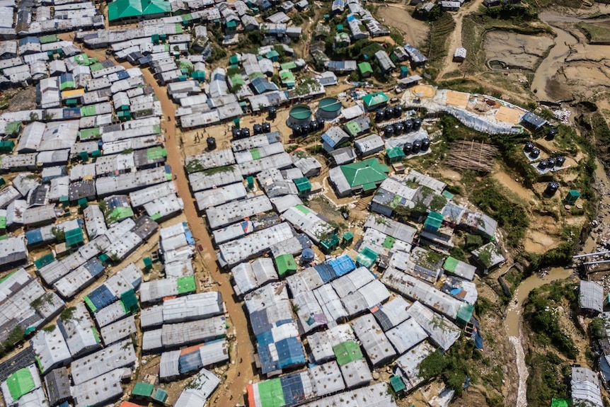 Many buildings and houses crowded together pictured from above, with people visible in the streets.