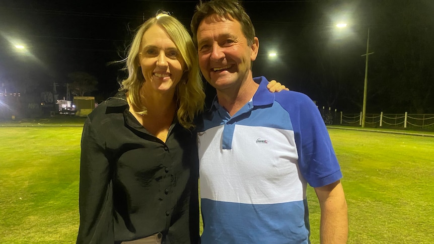 A man and a woman smile at the camera as they stand next to each other.