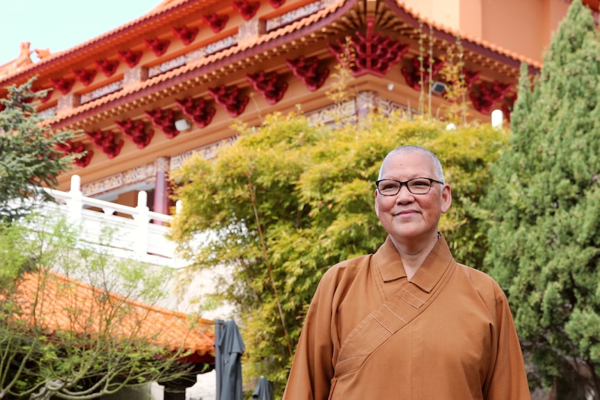 buddhist monk stand before temple