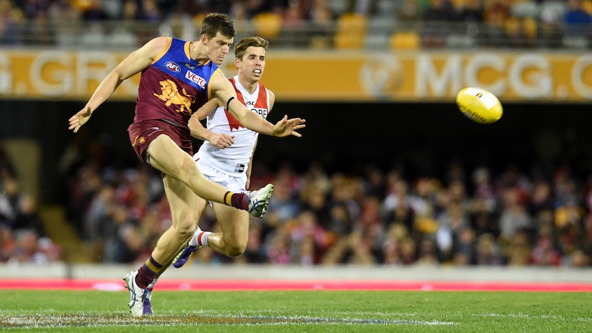 Brisbane Lions defender Justin Clarke kicks the ball against Sydney at the Gabba