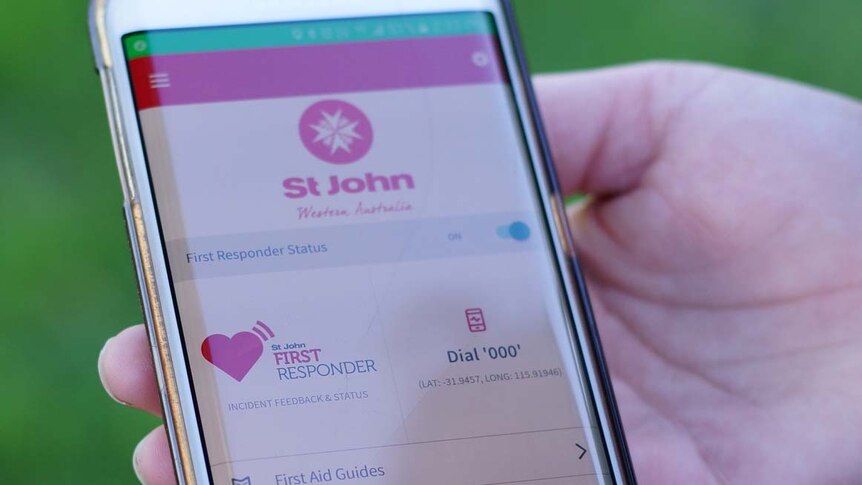 Person holding a smartphone with the St John app displayed.