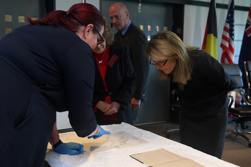 Caroline Kennedy examines a document.