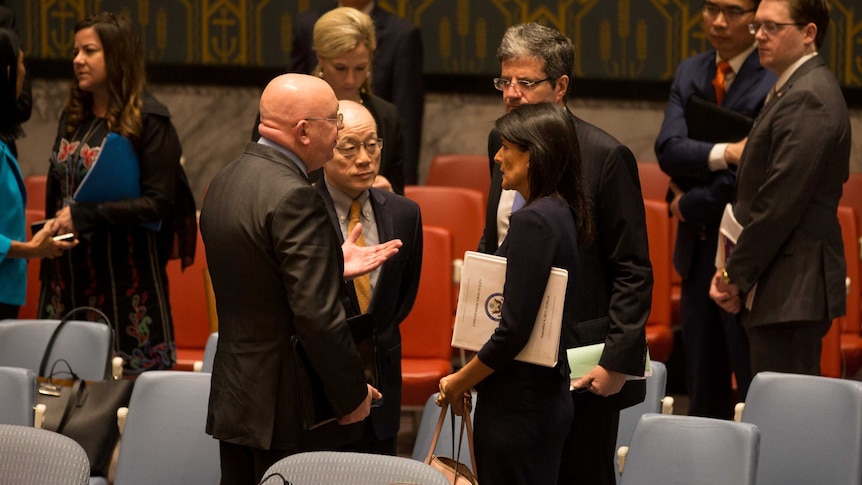 Diplomats from Russia, China and the United States stand around in discussion.