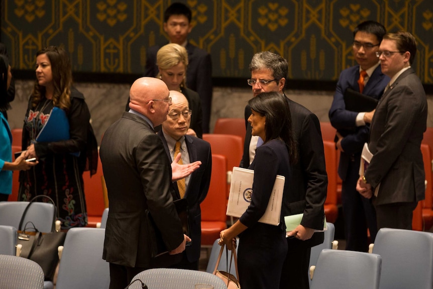 Diplomats from Russia, China and the United States stand around in discussion.