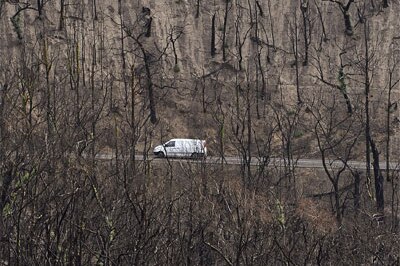 A car drives through a landscape devastated by bushfires in February near the township of Kinglake