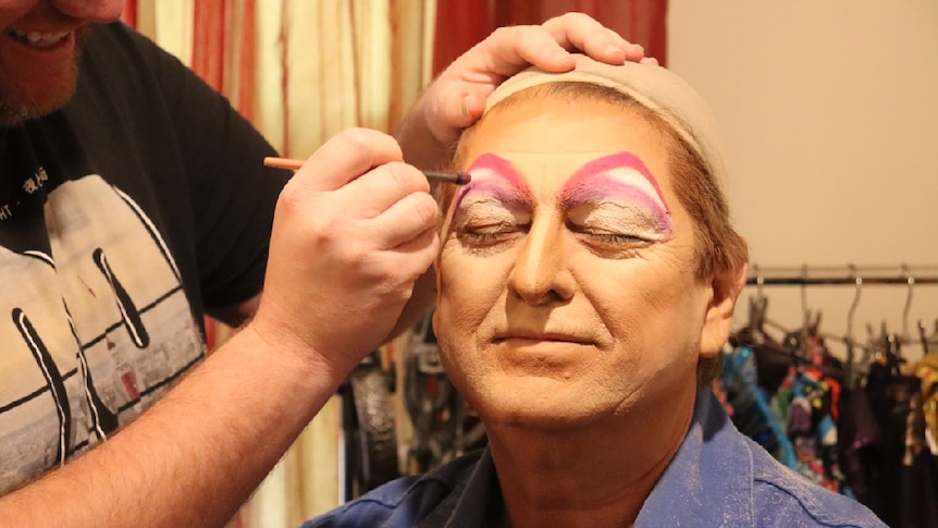 Broken Hill businessman Steve Radford gets his face painted by Brendan Barlow.