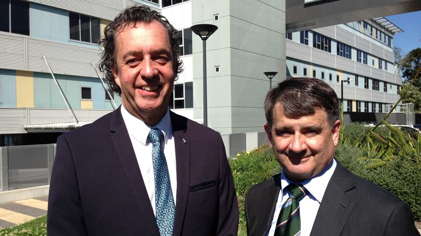 Leukemia patient Warren Lippiatt standing with Professor Stephen Mulligan at front of Royal North Shore Hospital in Sydney.