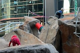 A photo of large rocks with two small children playing on top of them